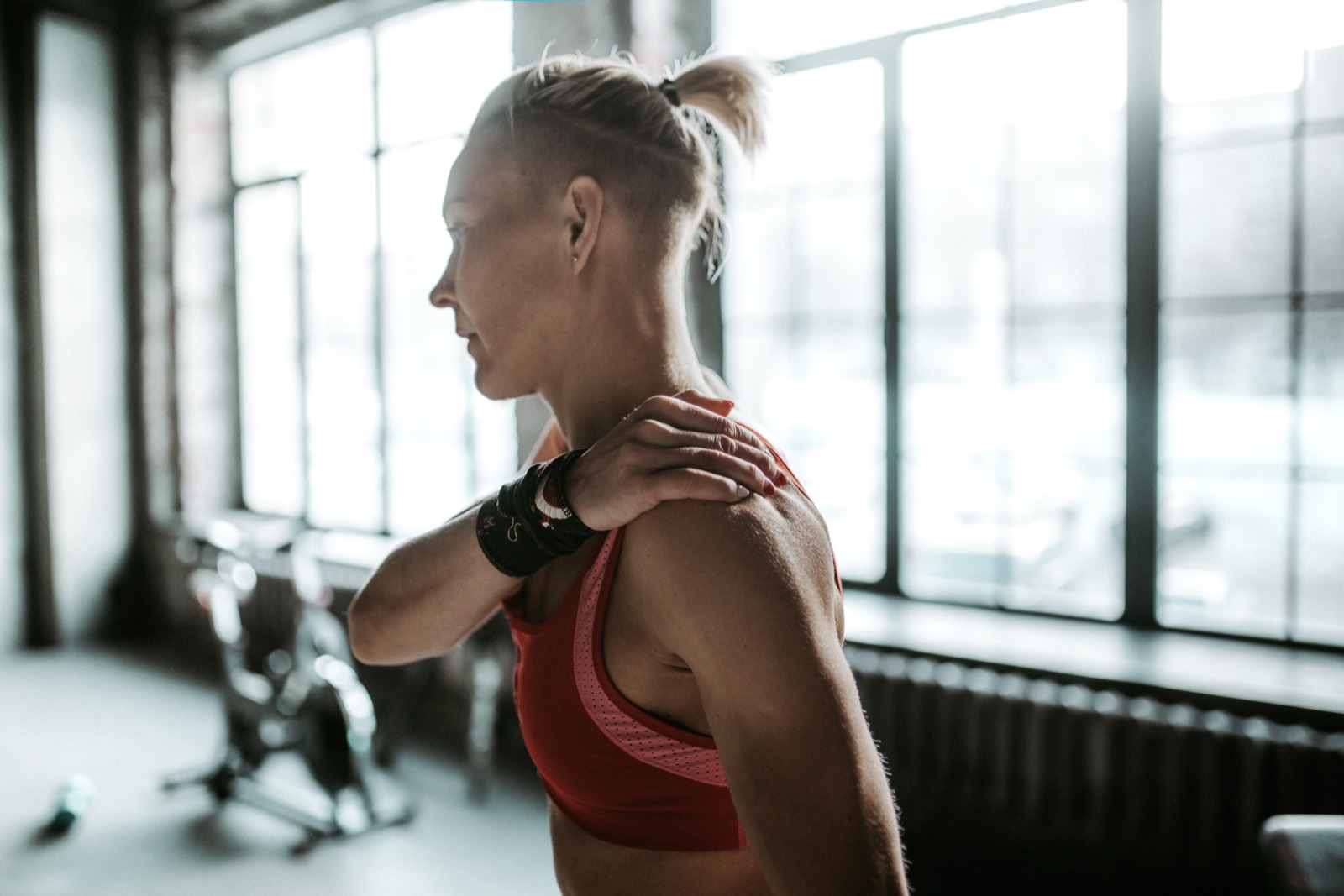 Woman at the gym holding her shoulder, a common symptom of a rotator cuff tear